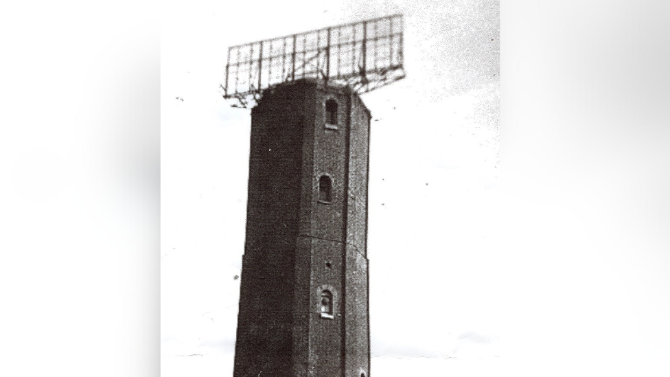 The top of the Naze Tower pictured in black and white. The picture was taken during World War Two, with a large radar dish on top of it.