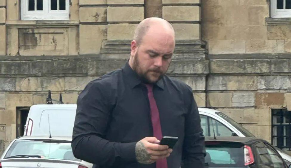 Cameron Ward stood outside York Crown Court on his phone