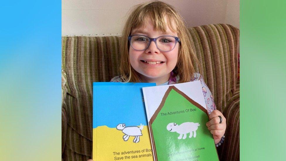 Amaya with the two books she has written and illustrated