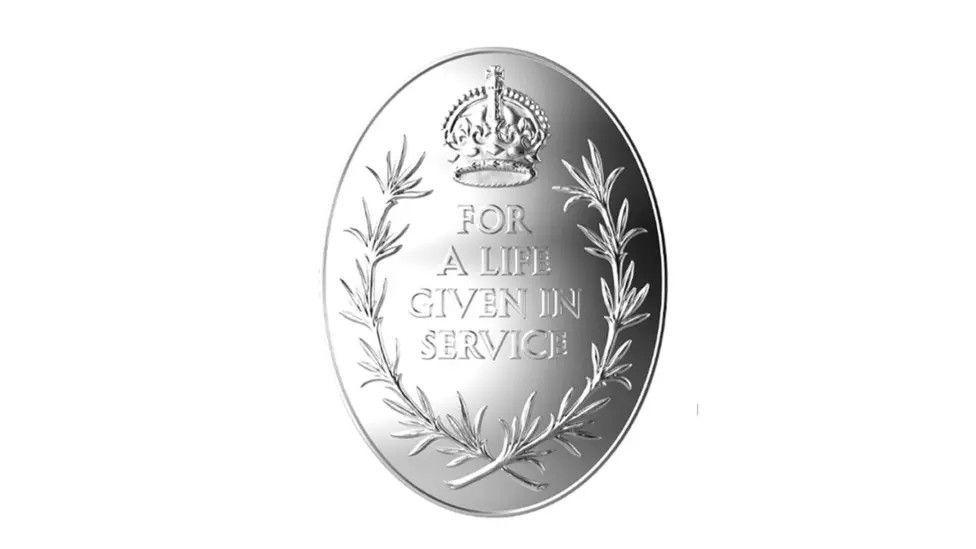 The Elizabeth Emblem - a silver medal with a rosemary wreath surrounding a Tudor Crown and the inscription "For A Life Given In Service".