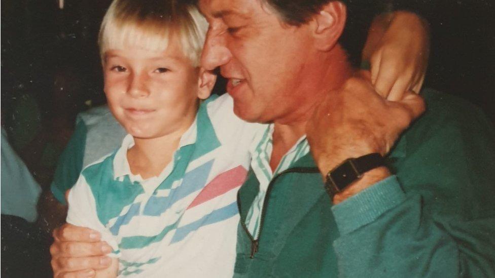 An old photo of Mark when he was a boy (left) with his arm around his dad wearing a green sweater and striped shirt