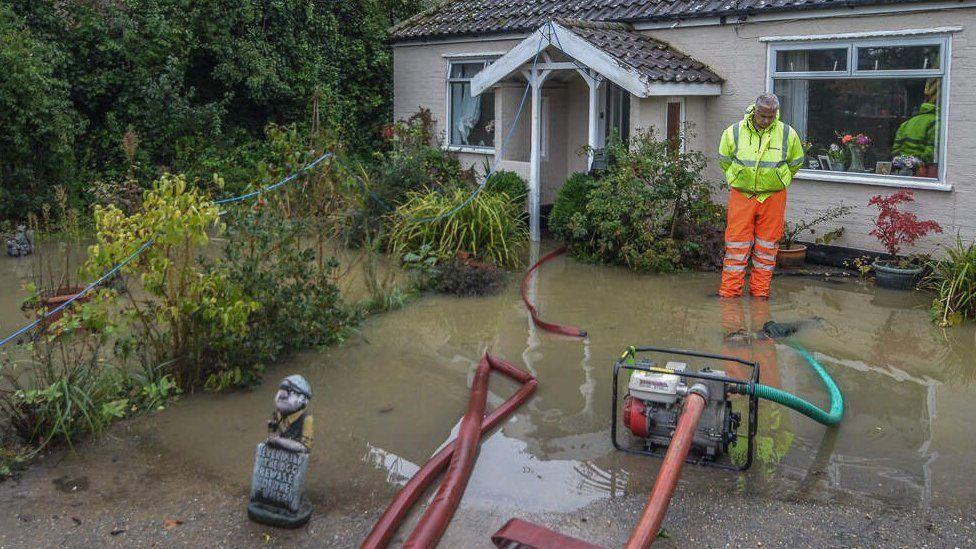 Pump and man in garden in Norfolk Road, Attleborough