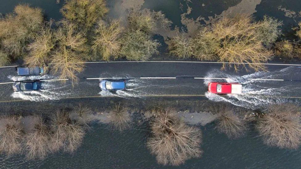 Cars driving through flooded road