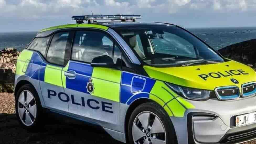 A car liveried with blue and yellow checked stickers and the word police on the side and bonnet.