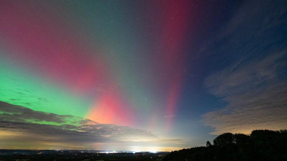 Blue sky with striped red, green and orange sky