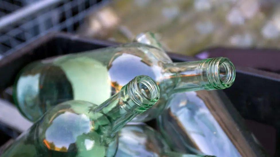 A close up view of several empty wine bottles in a plastic recycling box