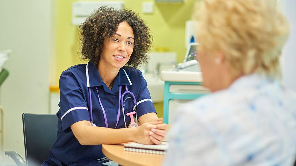 Stock image showing a doctor consulting an elderly patient in a GP surgery