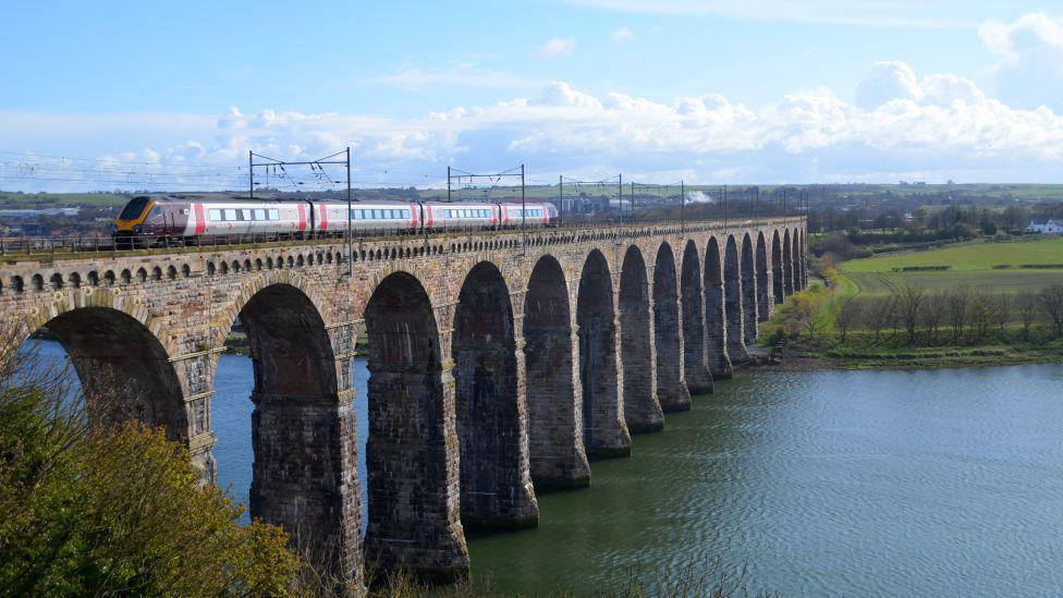 CrossCountry Voyager train passing Berwick-upon-Tweed on a bridge over a river.