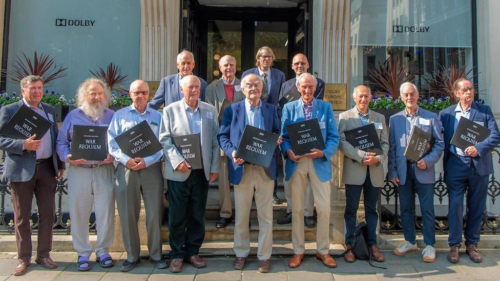 The choir who sang on Benjamin Britten's 1963 recording of his War Requiem are reunited outside the Dolby Studios headquarters in Soho, London