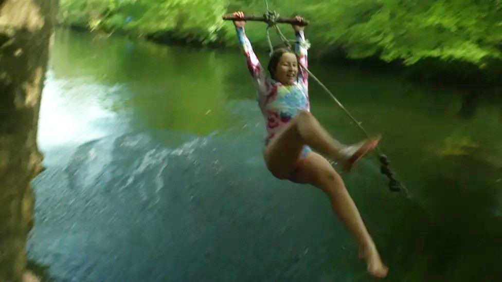 Eva Batho on a swing on the River Dart