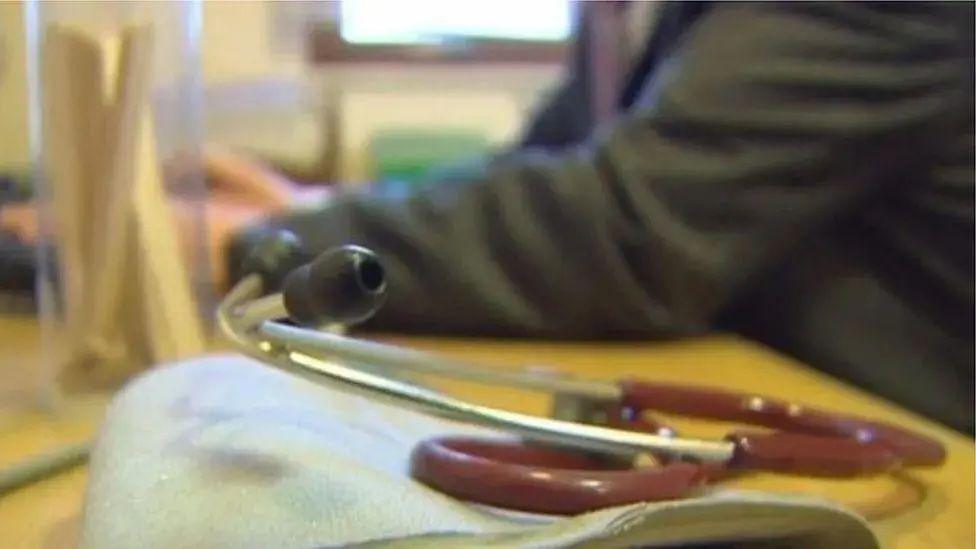 A closeup of a GPs desk with equipment to hear the heartbeat of a patient on the desk.