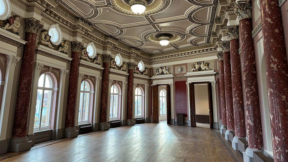 The newly restored main hall in the museum with purple marble pillars and sash windows with cream and brown plaster ceiling 