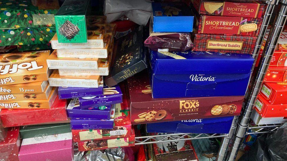 Shelves with boxes of Christmas biscuits, mince pies and chocolates 