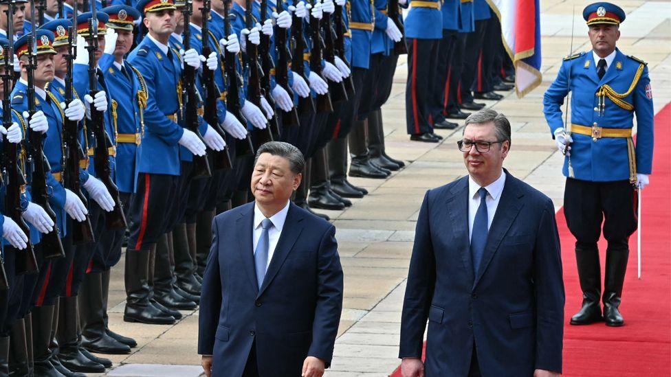 Serbian President Aleksandar Vucic walks with Chinese President Xi Jinping during a welcome ceremony in Belgrade