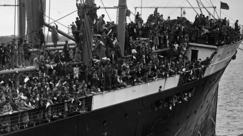 Black and white archive photograph of the bow of the SS Habana in port with hundreds of children standing on the decks