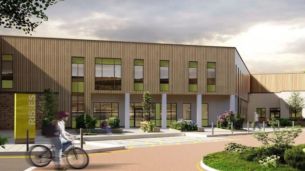 An artist's impression of what the hospital could look like. It is s two-storey building with light wooden cladding on the outside. There is a person in the foreground riding a bicycle.