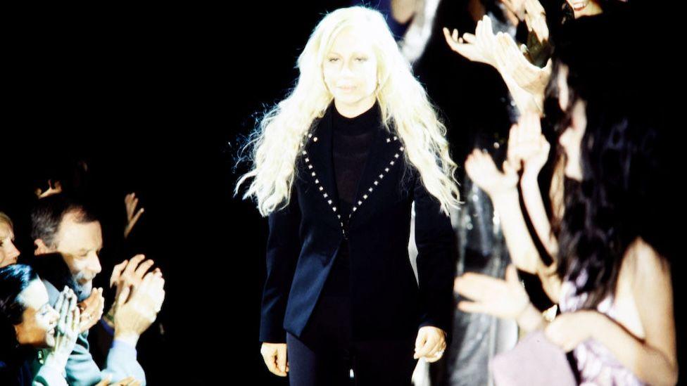 Dontella Versace in a black suit on the runway at her fashion show