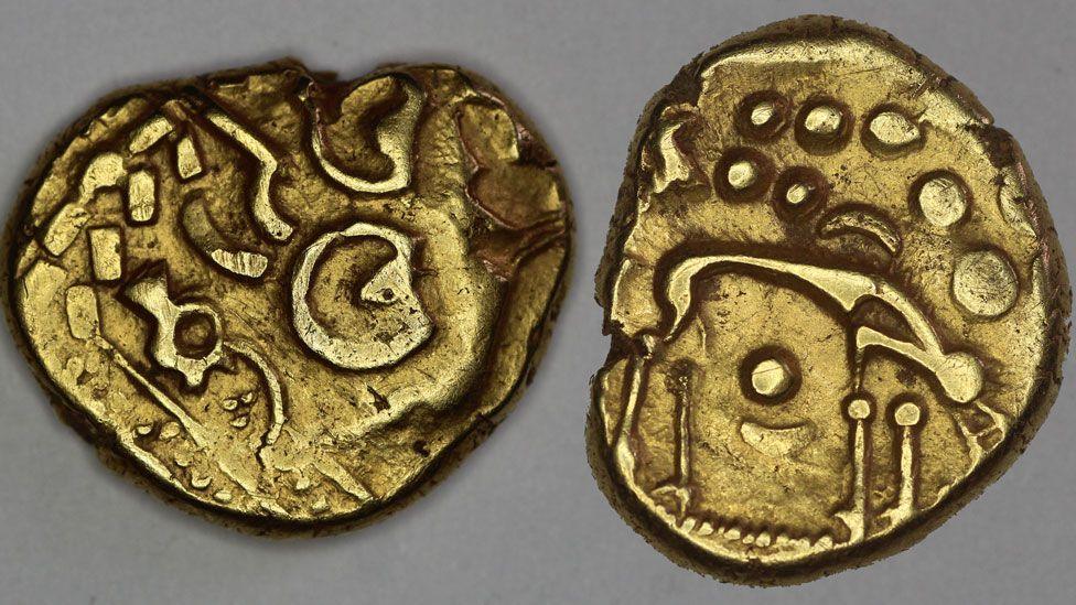 Two views of an Iron Ag gold stater. On the left it shows patterns struck in a die; on the right the design is of a stick figure of a wolf.