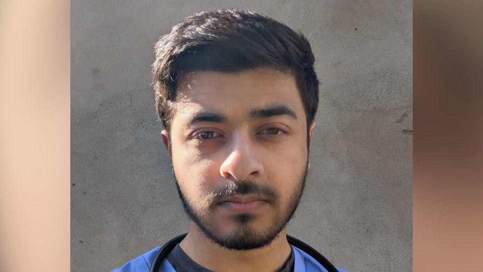 A picture of Raahat Shah, who is wearing a blue surgical uniform and a stethoscope around his neck.