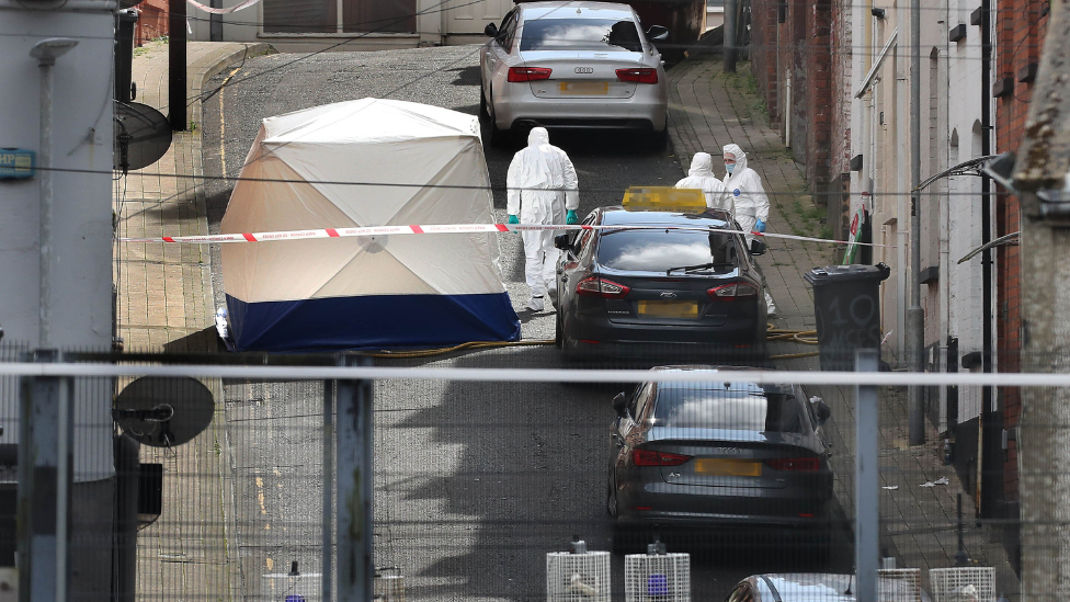 Forensic officers on Harvey Street in white suits, white tent on street outside a property, police tape and vehicle blocking road