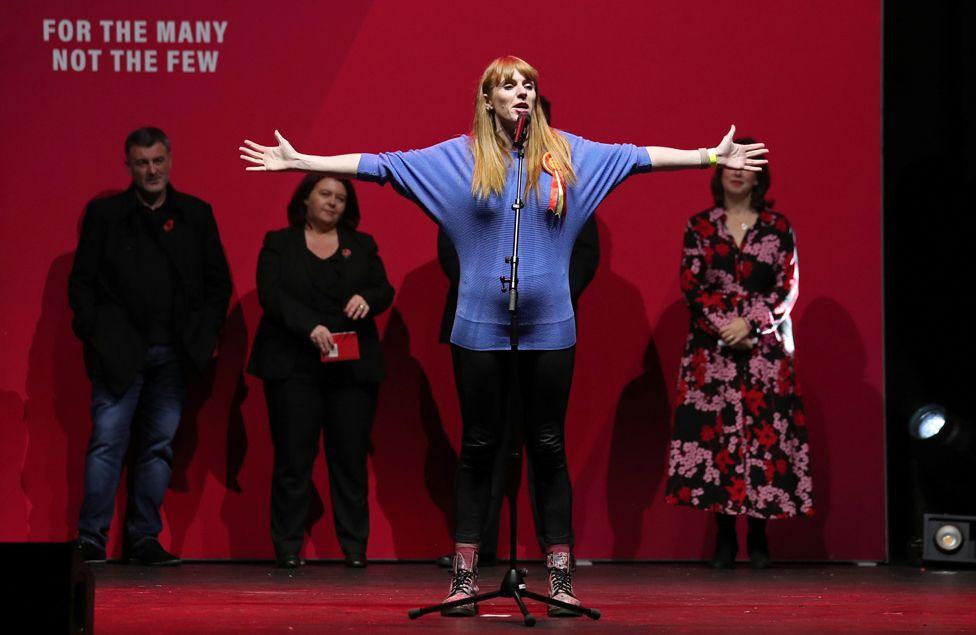 Labour's shadow education secretary Angela Rayner speaks at a general election campaign event in Manchester on 7 November 2019. She holds her hands out in front of a red screen.