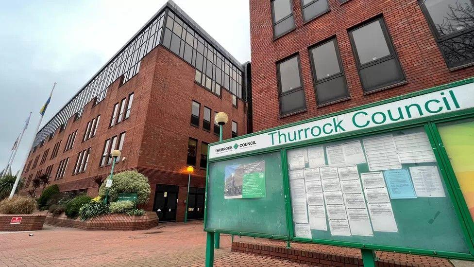 Thurrock Council offices, which are brick buildings with a green information sign in front.