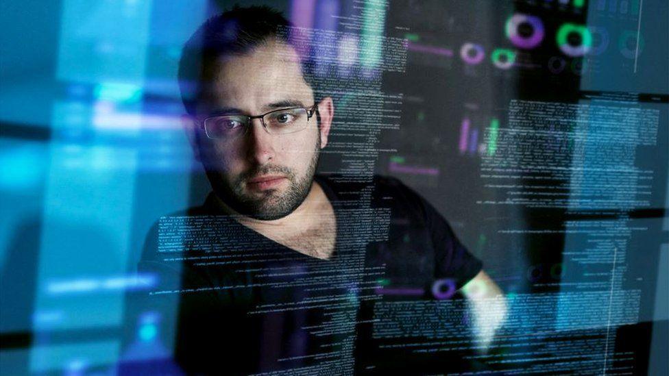 Stock photo, posed by a model, of a man looking at computer data 