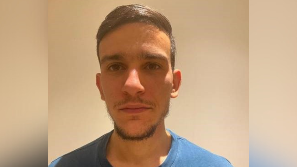 Nazim Kacem wearing blue t-shirt photographed against a plain cream background.