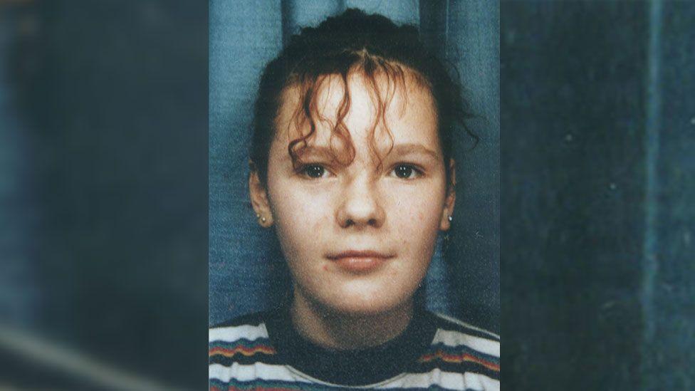A close-up passport style photo of Lindsay Rimer with tied up curly hair, believed to have been taken when she was around 13 years old.