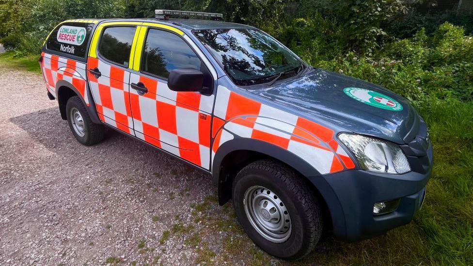 A lowland rescue vehicle with a red and white livery