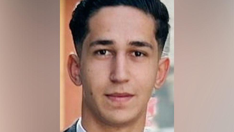 Young man - Abdullah - looking straight at the camera. He has short dark hair.