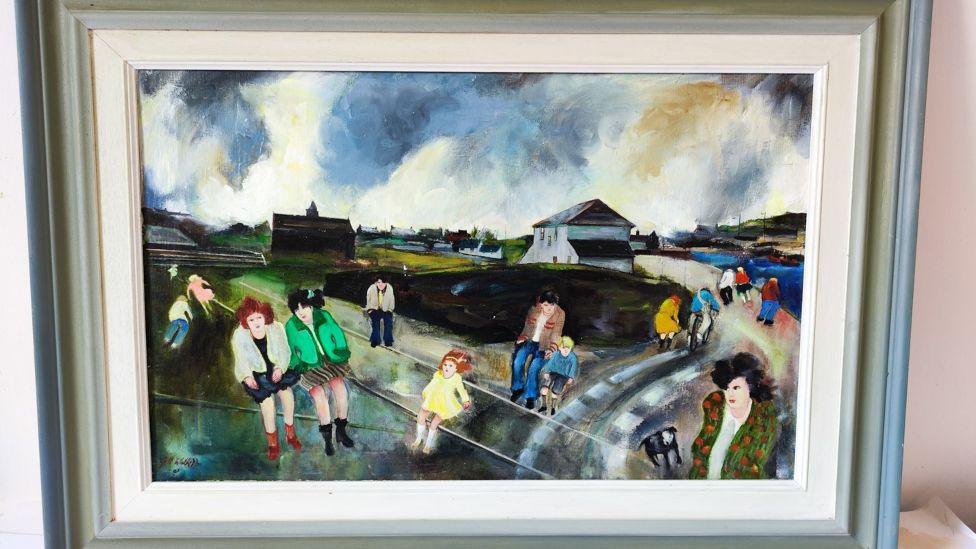 A painting of people walking in ones or twos around Penlee Park, with an expanse of water to the right, with some low storey buildings in view. The sky is full of clouds. In the foreground there is a woman with a bright green jacket and dark hair, walking with another woman in a black dress and white jacket.