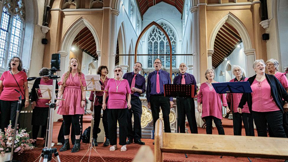 Choir singers perform in a church.