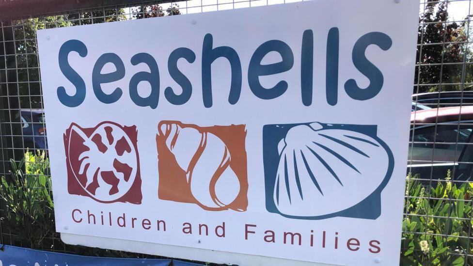 A sign outside the Seashells children's centre, with prints of three different shells.