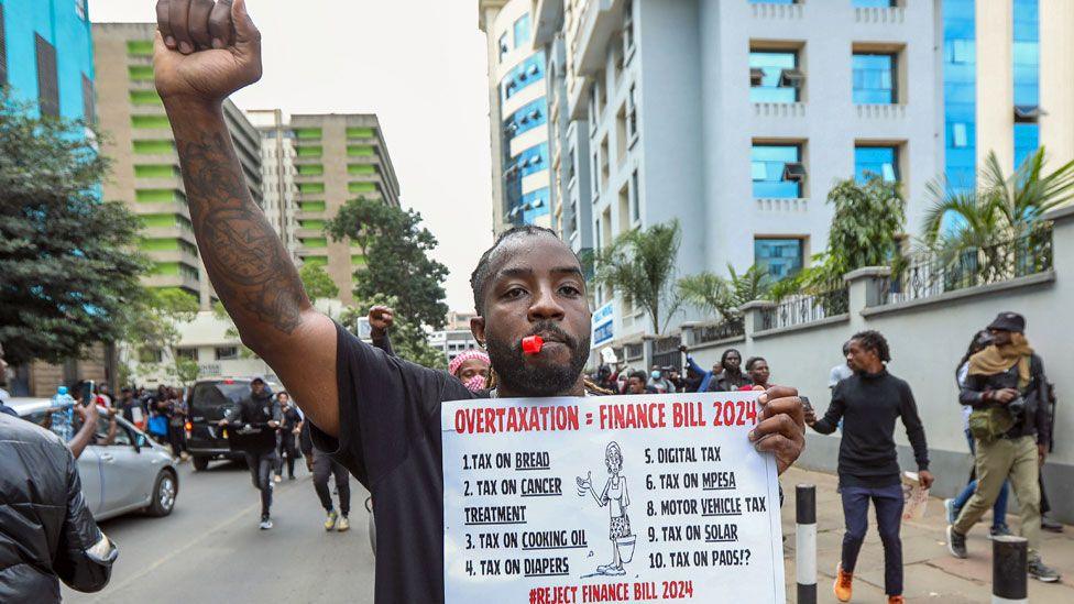 A Kenyan protester holds a placard during protests in Nairobi