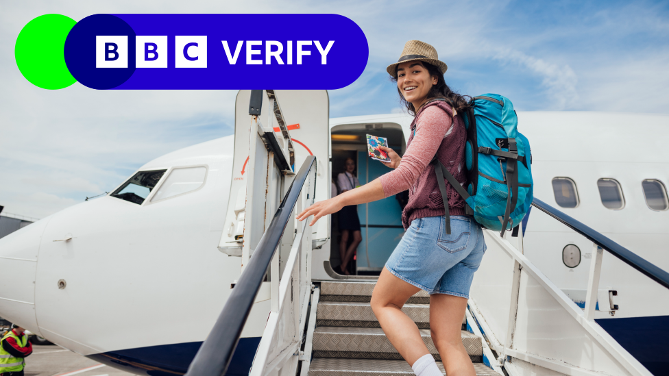 A smiling woman in shorts and a straw hat climbing the stairs to get onto an aeroplane. The BBC Verify logo is in the top left corner. 