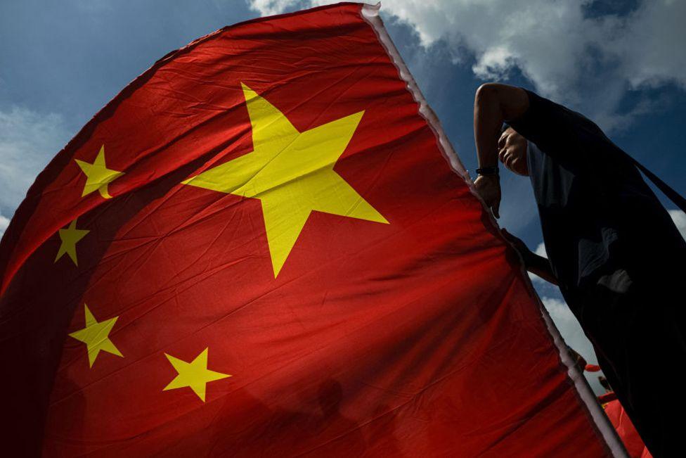 A person waves a flag of China during the 27th handover anniversary on July 1, 2024 in Hong Kong, China. 