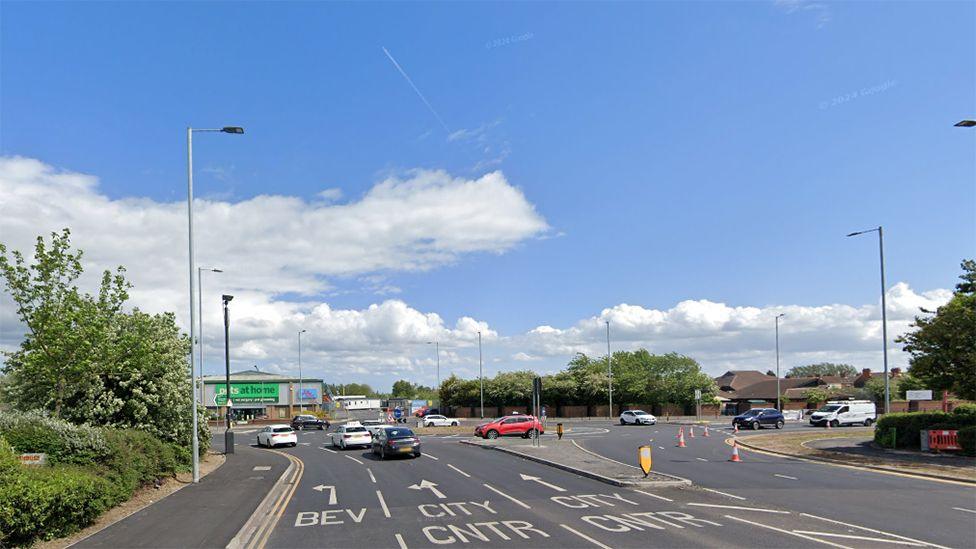 Google street view showing the roundabout at the Stoneferry/Ferry Lane junction with traffic waiting to drive across and white road markings showing a left turn arrow from the centre lane