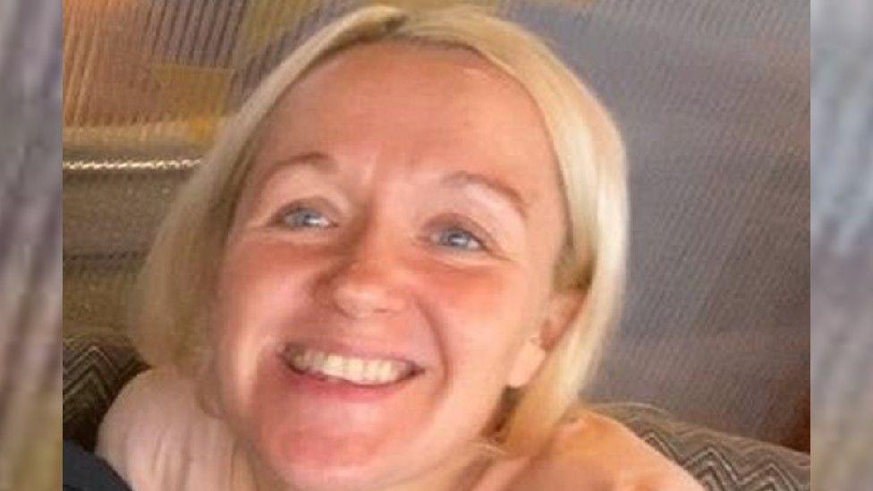 A woman with blonde hair smiles at the camera
