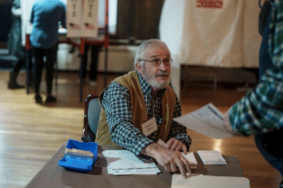 Gene Girdwood, ballot clerk, checks in voters to cast their ballots on 5 November 2024 in Bethlehem, New Hampshire.