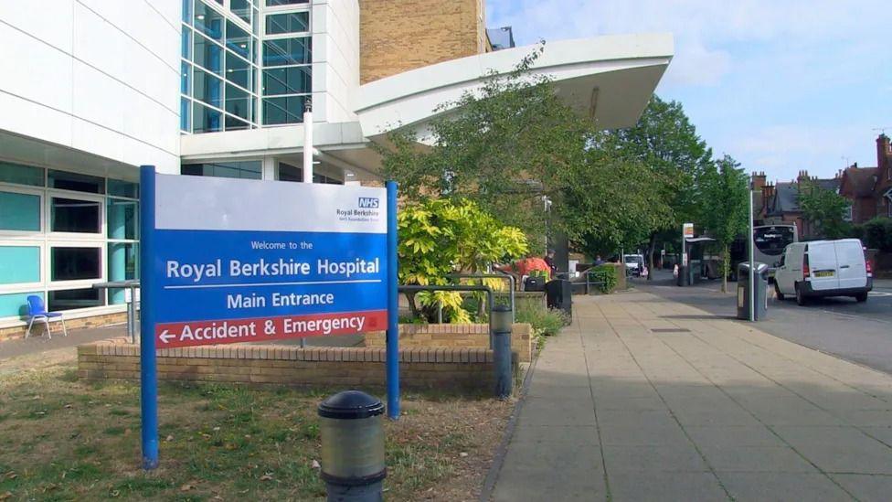 A white hospital entrance door with a sign saying 'Royal Berkshire Hospital main entrance'