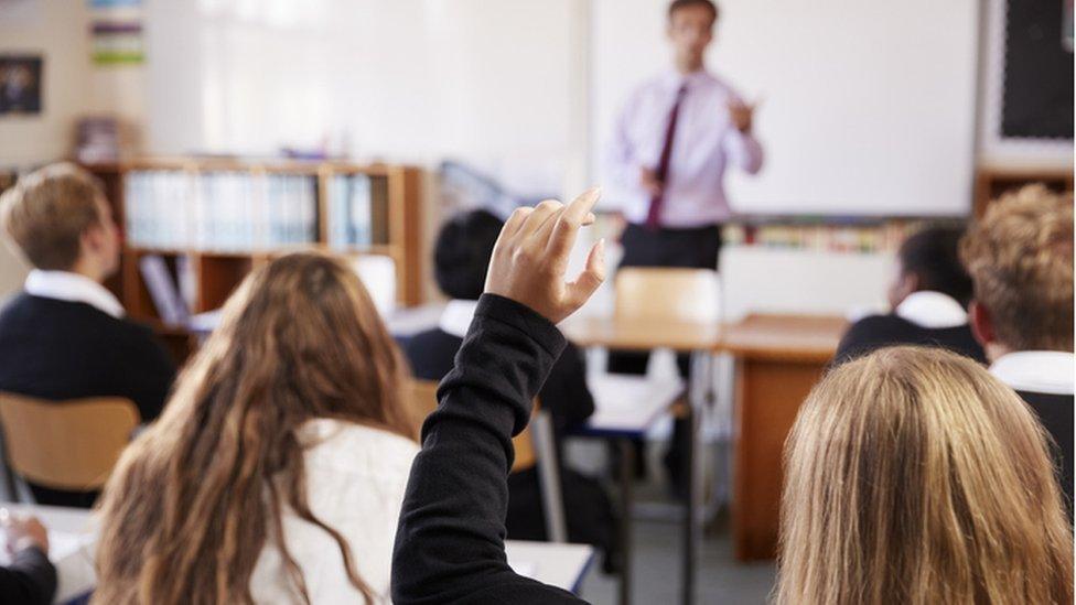 Students raising hand in class