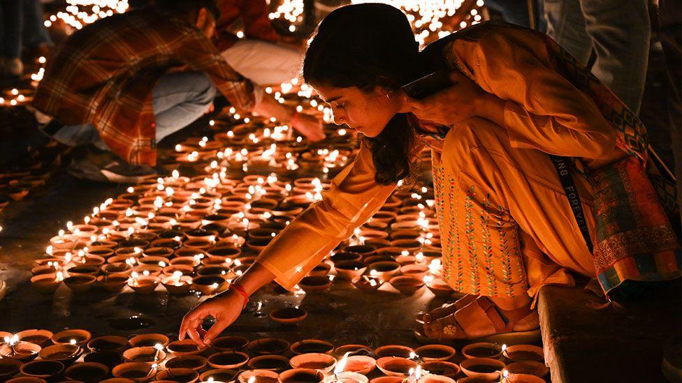 People light earthen lamps on the banks of Sarayu river during a programme, on the eve of Diwali, on November 11, 2023, Ayodhya