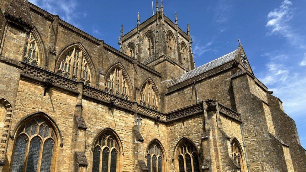 View of Sherborne Abbey  - medieval sandstone church building with bell tower