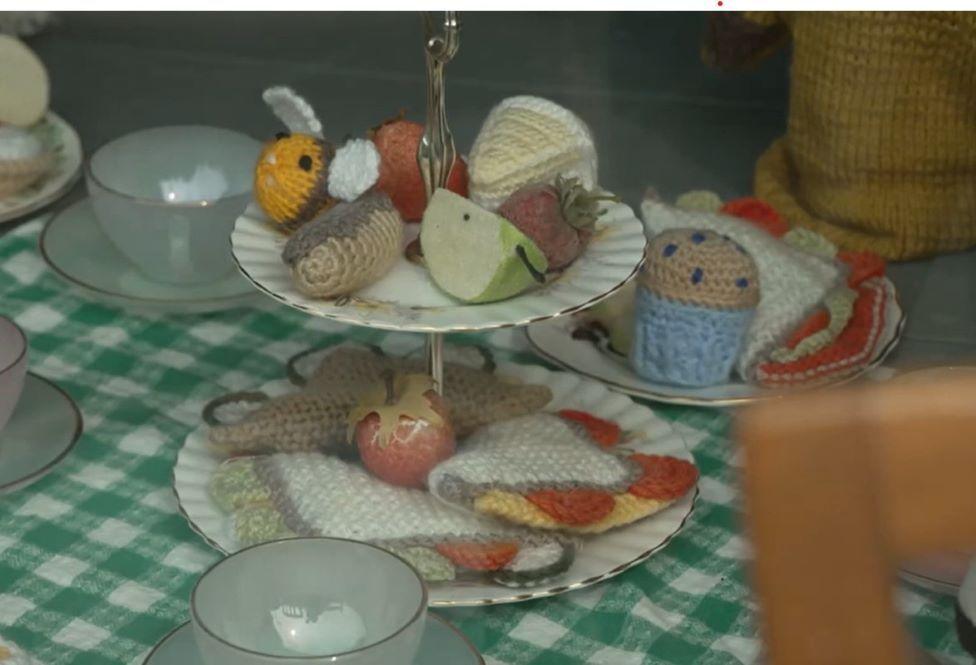 A knitted afternoon tea set made up of fruit, cakes and sandwiches