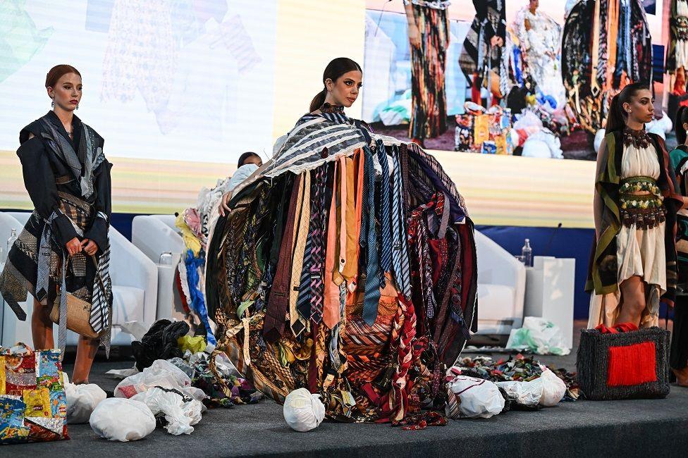 Several female models with long hair tied back on a podium - one with a robe with lots of old ties attached to it in Cairo, Egypt - Tuesday 5 November 2024