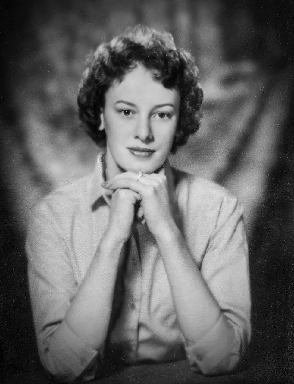 A black and white image of Sheila Brooks with curly hair in a light-coloured blouse in what looks like a studio type portrait