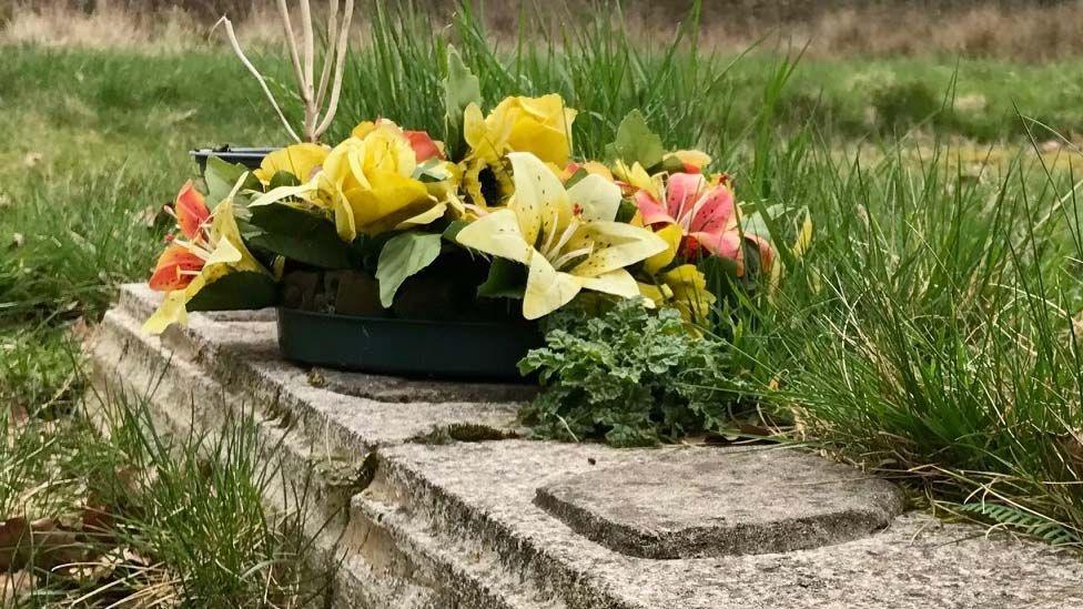 Flowers on a grave at Calderstones Hospital Cemetery