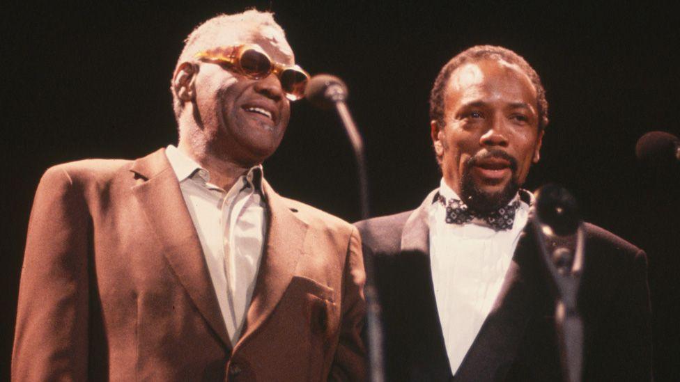 Ray Charles and Quincy Jones standing together on stage in 1986