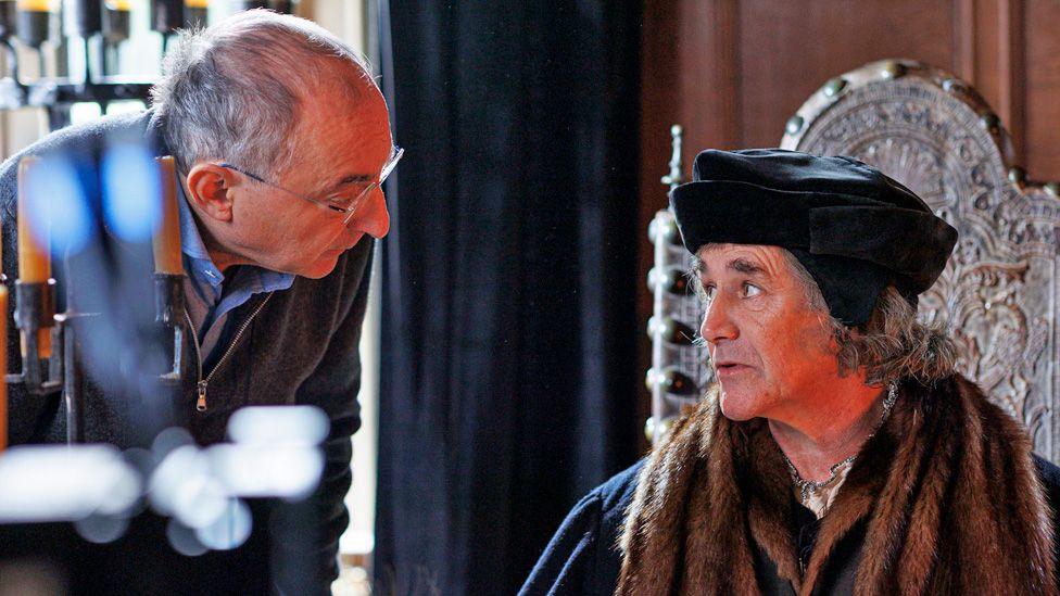 Peter Kosminsky speaking to Mark Rylance in costume while filming Wolf Hall